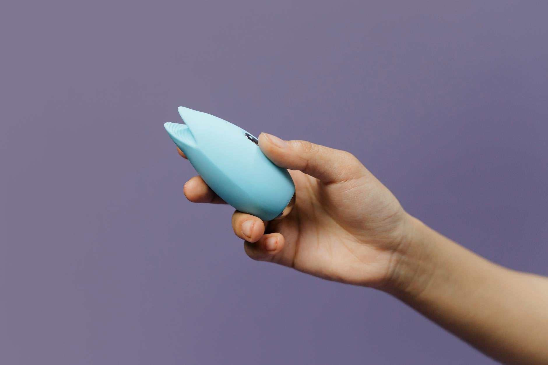 Colorful arrangement of vibrators displayed on a bright yellow surface, representing diverse approaches to pleasure